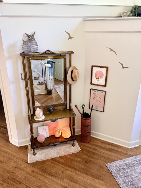 Entry vignette with a brass-and-bamboo hall stand, mirror, and salt lamps